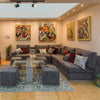 A well-furnished living room with our elegant Arrow L Shape Sofa and beautiful wall paintings.